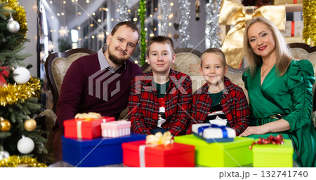 Family with mom and dad celebrates Christmas at home Family with mom and dad celebrates Christmas at home 132741740