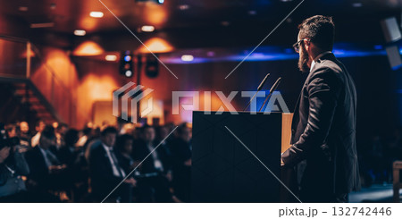 Speaker giving a talk on corporate business conference. Unrecognizable people in audience at conference hall. Business and Entrepreneurship event. 132742446