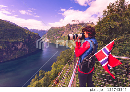 Tourist taking photo of fjord landscape, Norway Tourist taking photo of fjord landscape, Norway 132743545