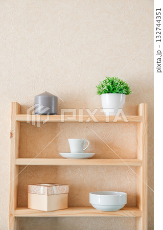 candle, decorative flower, mug, bowl, gift box on shelves 132744351