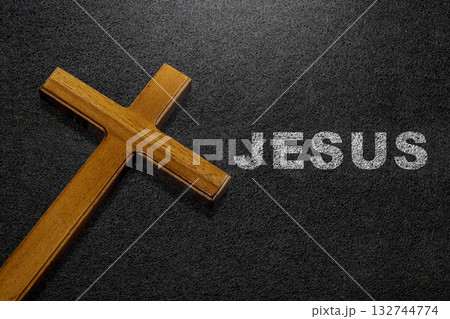 Christian cross with Jesus text on the table. Concept of Christianity, religious, faith, Jesus, or belief 132744774