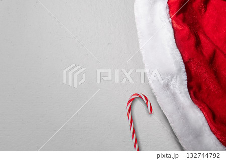 Santa hat with a candy cane on a white background. Mockup or Copy space for holiday greetings or winter themes Santa hat with a candy cane on a white background. Mockup or Copy space for holiday greetings or winter themes 132744792