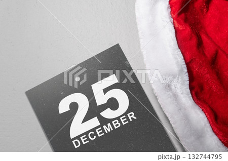 Santa hat and calendar showing 25 December on a white background. Mockup or Copy space. Holiday greetings or winter themes. Concept of the Merry Christmas celebration Santa hat and calendar showing 25 December on a white background. Mockup or Copy space. Holiday greetings or winter themes. Concept of the Merry Christmas celebration 132744795