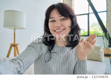 Selfie portrait happy beautiful young woman in home interior 132744876