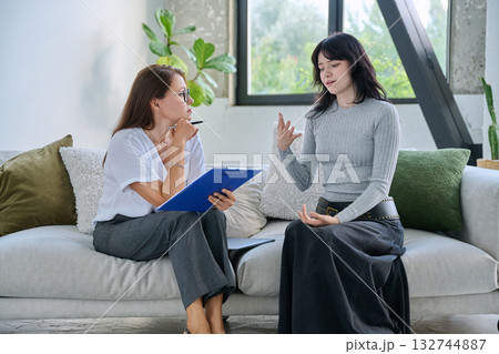 Young female patient in therapy session talking with female psychologist Young female patient in therapy session talking with female psychologist 132744887