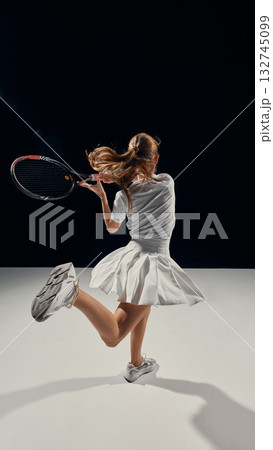 Teenage athlete performing elegant tennis motion with calm confidence 132745099