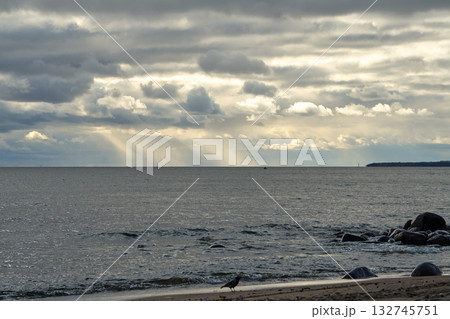 Dramatic cloudy sky with sun rays over calm sea horizon in daylight. Dramatic cloudy sky with sun rays over calm sea horizon in daylight. 132745751
