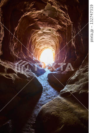 Belly of the Dragon Cave Tunnel Interior with Sunlit Exit Trail Utah 132747319