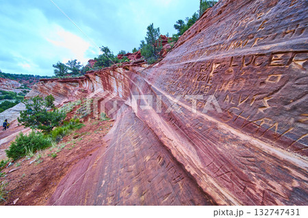 Sandstone Graffiti Wall and Hikers in Red Rock Desert Kanab Utah Wide Angle Sandstone Graffiti Wall and Hikers in Red Rock Desert Kanab Utah Wide Angle 132747431