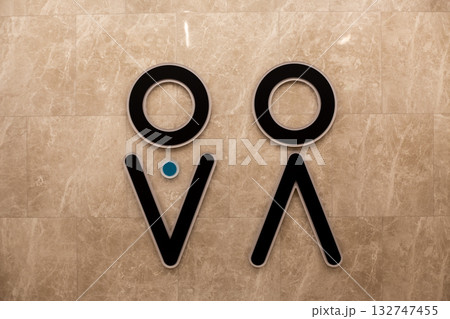 Wall with universal gender symbols for men and women indicating left for men and right for women in sex public restroom. Concept for hygiene and universal design for public accessible environment 132747455