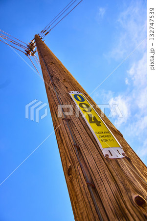 Wooden Utility Pole with Energy Identification and Power Lines Against Blue Sky Wooden Utility Pole with Energy Identification and Power Lines Against Blue Sky 132747539