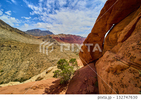 Red Rock Arch Desert Landscape and Distant Mountains under Bright Blue Sky Red Rock Arch Desert Landscape and Distant Mountains under Bright Blue Sky 132747630