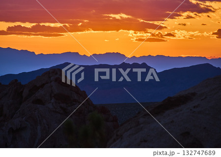 Sunset Light Over Layered Mountains and Rocky Formations at Golden Hour 132747689