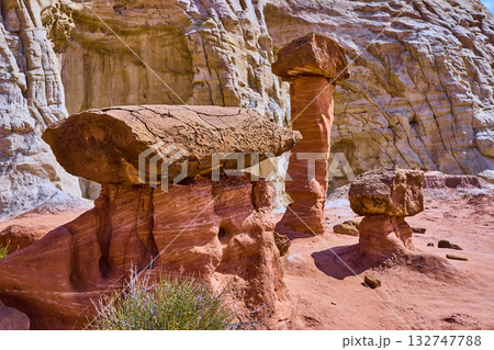 Toadstool Hoodoos and Striated Cliffs in Sunlit Utah Desert Landscape Toadstool Hoodoos and Striated Cliffs in Sunlit Utah Desert Landscape 132747788