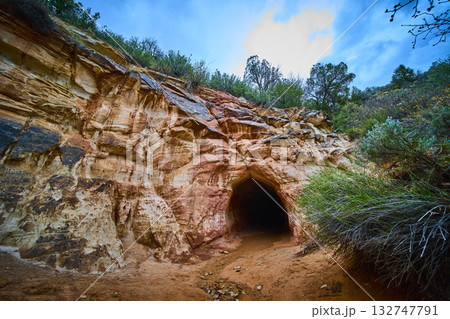 Sandstone Cave Entrance in Desert Cliff with Sagebrush Kanab Utah Low Angle Sandstone Cave Entrance in Desert Cliff with Sagebrush Kanab Utah Low Angle 132747791