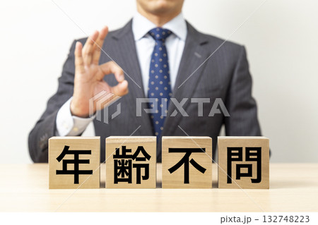 「年齢不問」と書かれたブロックとOKポーズをするビジネスマン 132748223
