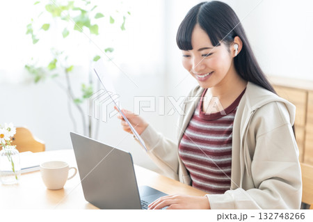 書類を手にリモートで打ち合わせをする若い女性 132748266