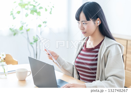 書類を手にリモートで打ち合わせをする若い女性 132748267