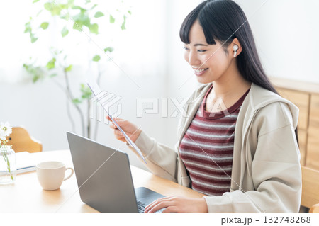 書類を手にリモートで打ち合わせをする若い女性 132748268