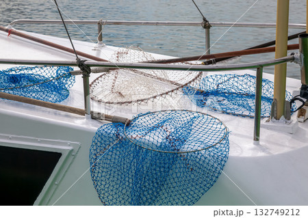 船のデッキの上に置かれた柄ついたタモ網 132749212