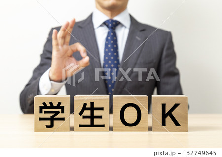 「学生OK」と書かれたブロックとOKポーズをするビジネスマン 132749645