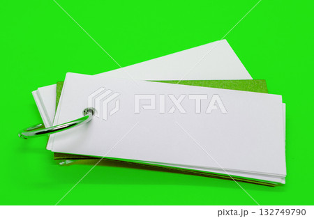 Close up of white banner shape notepad with customizable space for text on green cover background. Copy space concept. Close up of white banner shape notepad with customizable space for text on green cover background. Copy space concept. 132749790