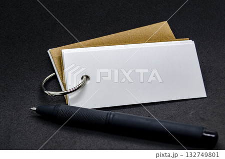 White banner shape notepad with customizable space for text on black cover background and black pen. Copy space concept. 132749801