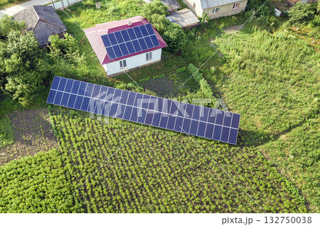 Aerial view of a house with blue solar panels for clean energy. Aerial view of a house with blue solar panels for clean energy. 132750038