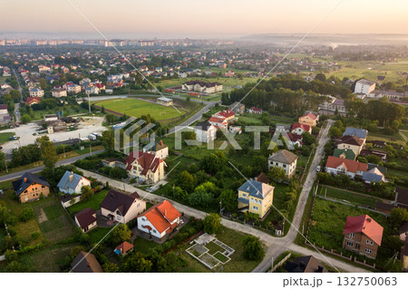 Aerial landscape of small town or village with rows of residential homes and green trees. 132750063