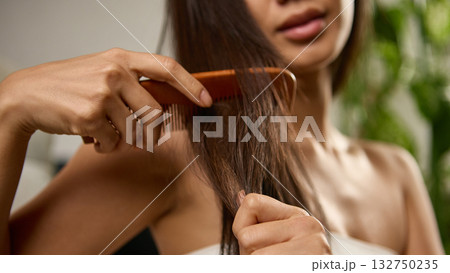 Close view of woman combing hair showing strength softness and health 132750235