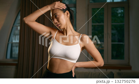 Woman stretching neck muscles at indoors after home workout Woman stretching neck muscles at indoors after home workout 132750276