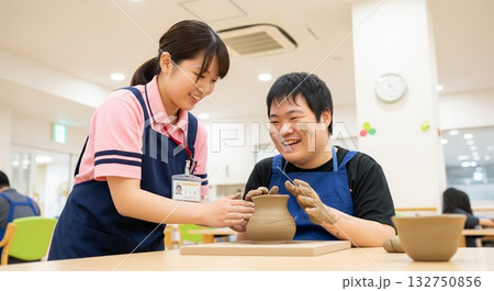 粘土細工を楽しむ笑顔の障がい者と優しくサポートする女性支援員（創作活動）　陶芸教室　アート　芸術活動 132750856