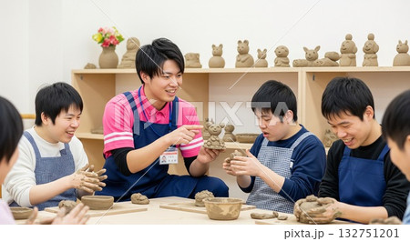 粘土細工をしながら笑顔で利用者と交流する男性支援員（福祉・作業所）粘土・陶芸、創作レクリエーション 132751201