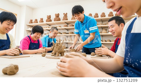 粘土細工をしながら笑顔で利用者と交流する男性支援員（福祉・作業所）粘土・陶芸、創作レクリエーション 132751209