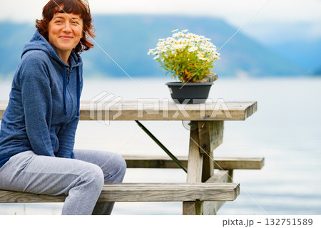 Woman tourist relax on fjord shore, Norway Woman tourist relax on fjord shore, Norway 132751589
