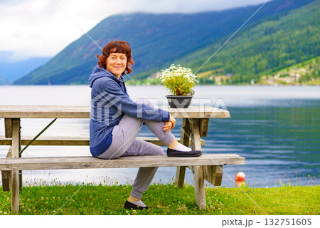 Woman tourist relax on fjord shore, Norway 132751605