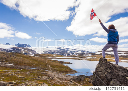 Tourist with norwegian flag in mountains 132751611