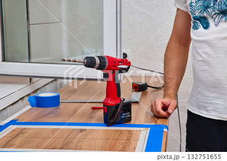 repairman using electric drill and installation new modern kitchen 132751655