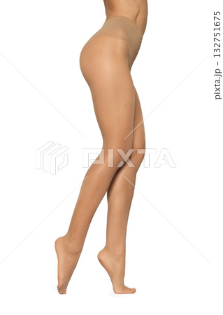 Beautiful long fit female legs in beige tights on white background 132751675