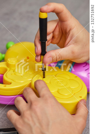 Father repairing toy using screwdriver at home Father repairing toy using screwdriver at home 132751692