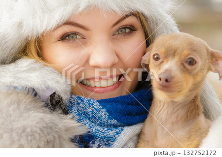 Woman playing with dog during winter 132752172
