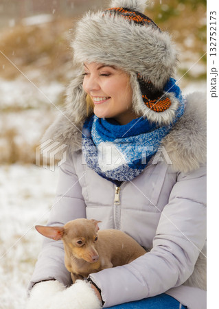 Woman playing with dog during winter 132752173