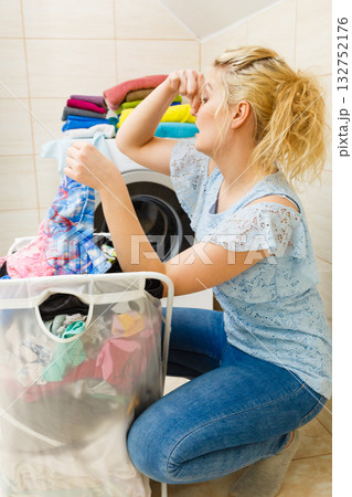 Unhappy girl with dirty clothes laundry. Unhappy girl with dirty clothes laundry. 132752176
