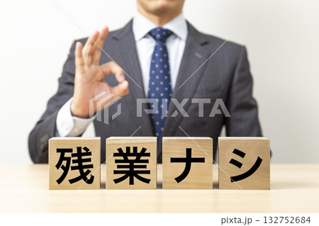 「残業ナシ」と書かれたブロックとOKポーズをするビジネスマン 132752684