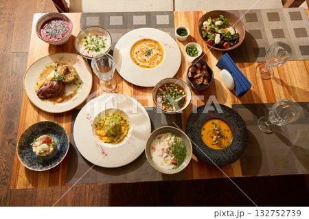 An Exquisite Dining Experience Featuring Varied Dishes Presented on a Rustic Table 132752739
