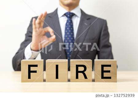「FIRE」と書かれたブロックとOKポーズをするビジネスマン 「FIRE」と書かれたブロックとOKポーズをするビジネスマン 132752939