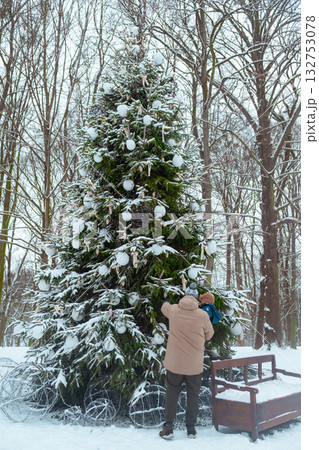 Decorating a Christmas tree in a snowy forest 132753078