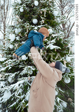 Father and Child by Snowy Christmas Tree Father and Child by Snowy Christmas Tree 132753085