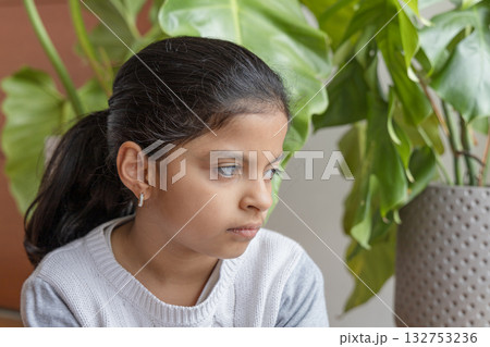 Autistic girl, sitting while thinking about something. Autistic girl, sitting while thinking about something. 132753236