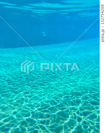 Close-up of the water of a swimming pool with the sunlight reflection. The scene of the swimming pool in the sunny day. Relaxation and holiday concept. Close-up of the water of a swimming pool with the sunlight reflection. The scene of the swimming pool in the sunny day. Relaxation and holiday concept. 132754209
